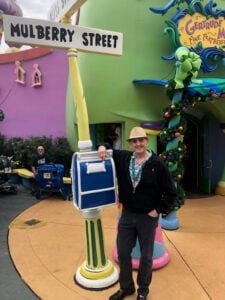 David Richardson at Universal Studios posing with a Dr. Suess "Mulberry St" signpost (Courtesy of David Richardson)