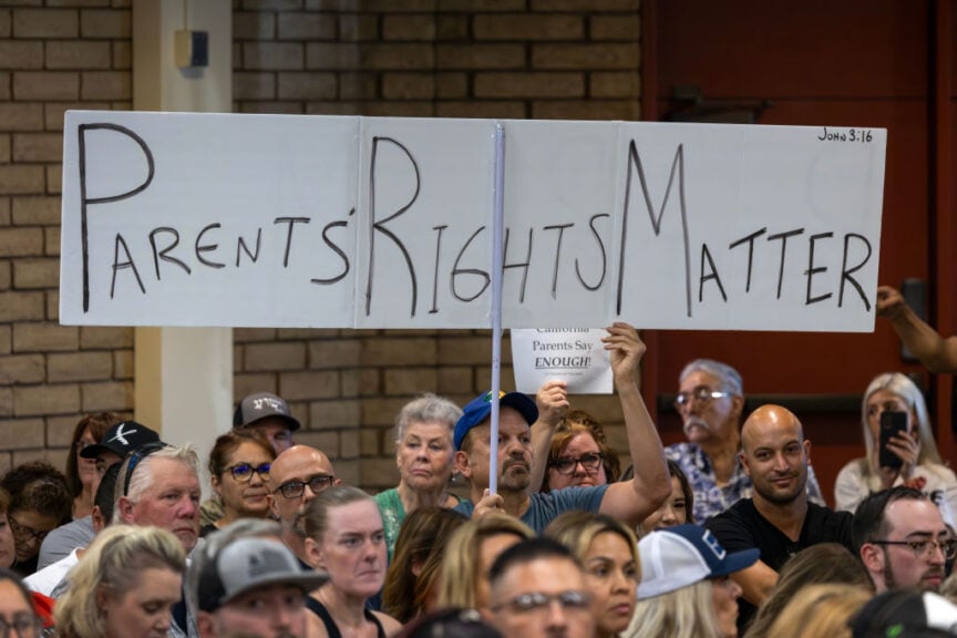 CHINO, CALIFORNIA - JULY 20: A man holds a sign in support of a policy that the Chino Valley school board is meeting to vote on which would require school staff to "out" students to their parents if they ask to be identified by a gender that is not listed on their birth certificate on July 20, 2023 in Chino, California. In June, the board voted 4-1 to revise guidelines for ceremonies and observances that would only allow U.S., California, military, foreign nations and flags of higher education institutions, effectively banning LGBTQ+ pride flags from being displayed on school district property. Today's vote is a continuation of the June meeting discussion of matters affecting LGBTQ+ students. 