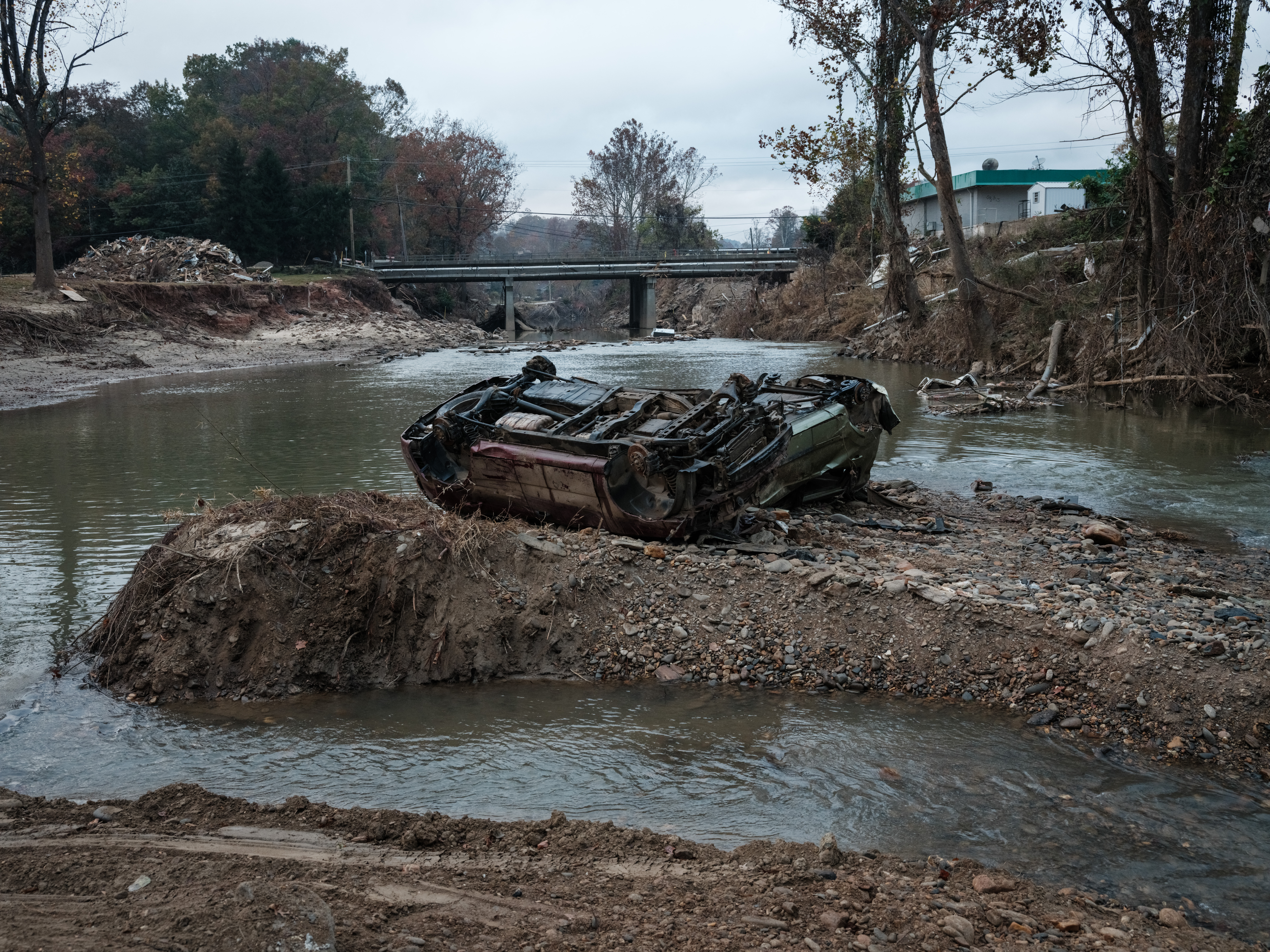 Destroyed cars remain in a river after the flooding caused by Hurricane Helene about a month ago in Asheville, North Carolina, on October 30, 2024.