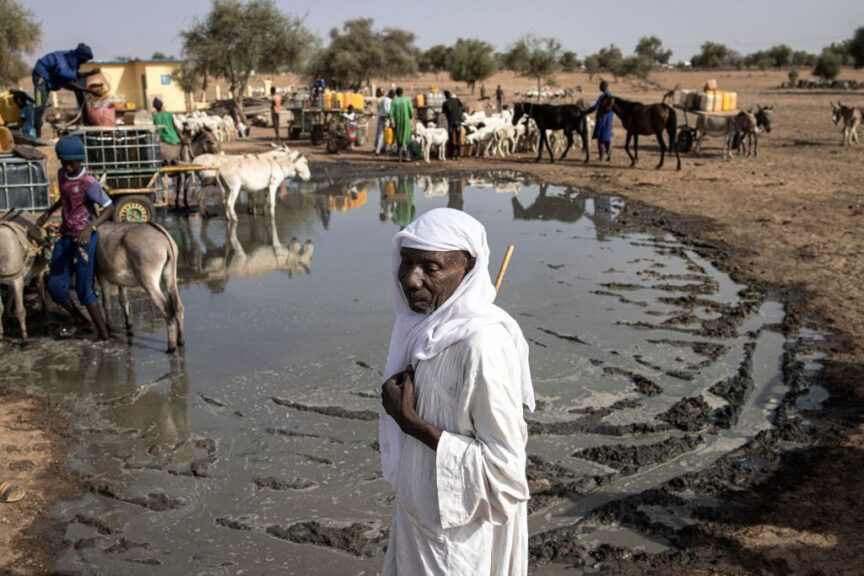 TOPSHOT - A Fulani pastoralist rests at a water point in Loumbel Lana, Matam region on May 19, 2023. For pastoralist the extreme heats direct effect is that their livestock drink double what they usually do. Usually one sheep will drink around 2,5 litres of water a day, now they need 4 or 5 litres a day. Pastoralists now need to get to water points multiple times a day (up to 20km away) and spend double the money buying water. Since April the region of Matam has regularly been flagged as the hottest place on earth with temperatures reaching 48 degrees celsius in the shade and fifties in direct sun. (Photo by JOHN WESSELS / AFP) (Photo by JOHN WESSELS/AFP via Getty Images)