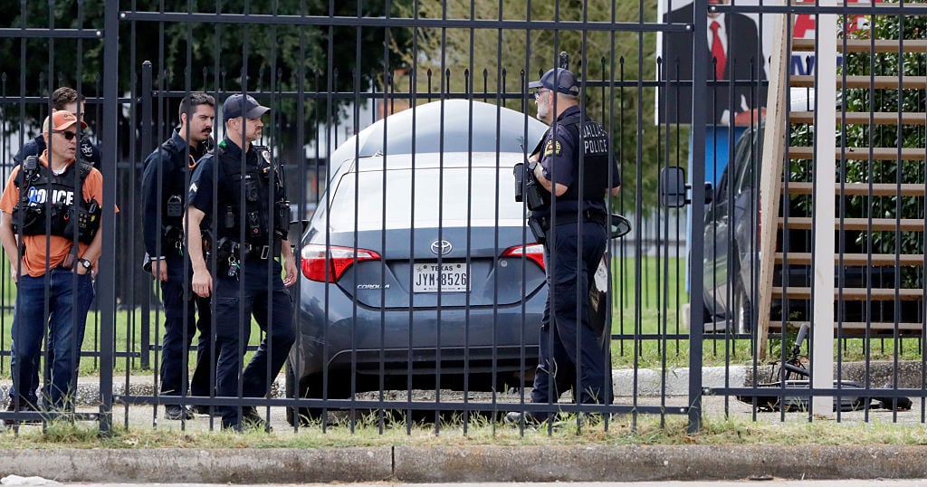 Officers respond after a shooter opens fire on an ICE facility in Dallas.