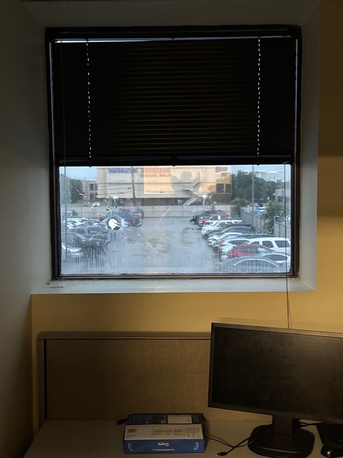 A bullet hole is seen in a window of the ICE facility in Dallas.