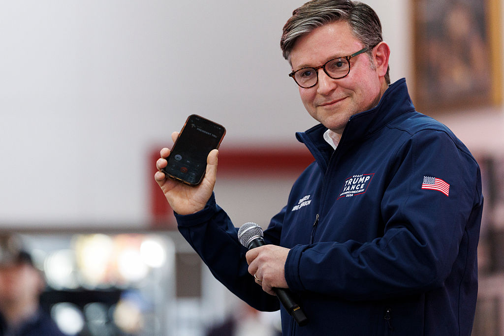 FRANKLIN, TENNESSEE - DECEMBER 1: House Speaker Mike Johnson (R-LA) holds his phone to the microphone during a call with U.S. President Donald Trump during a get out the vote event held in support of Republican congressional candidate Matt Van Epps on December 1, 2025 in Franklin, Tennessee. Tennessee's 7th congressional district special election is being held to fill the seat vacated following the resignation of republican Mark Green. 